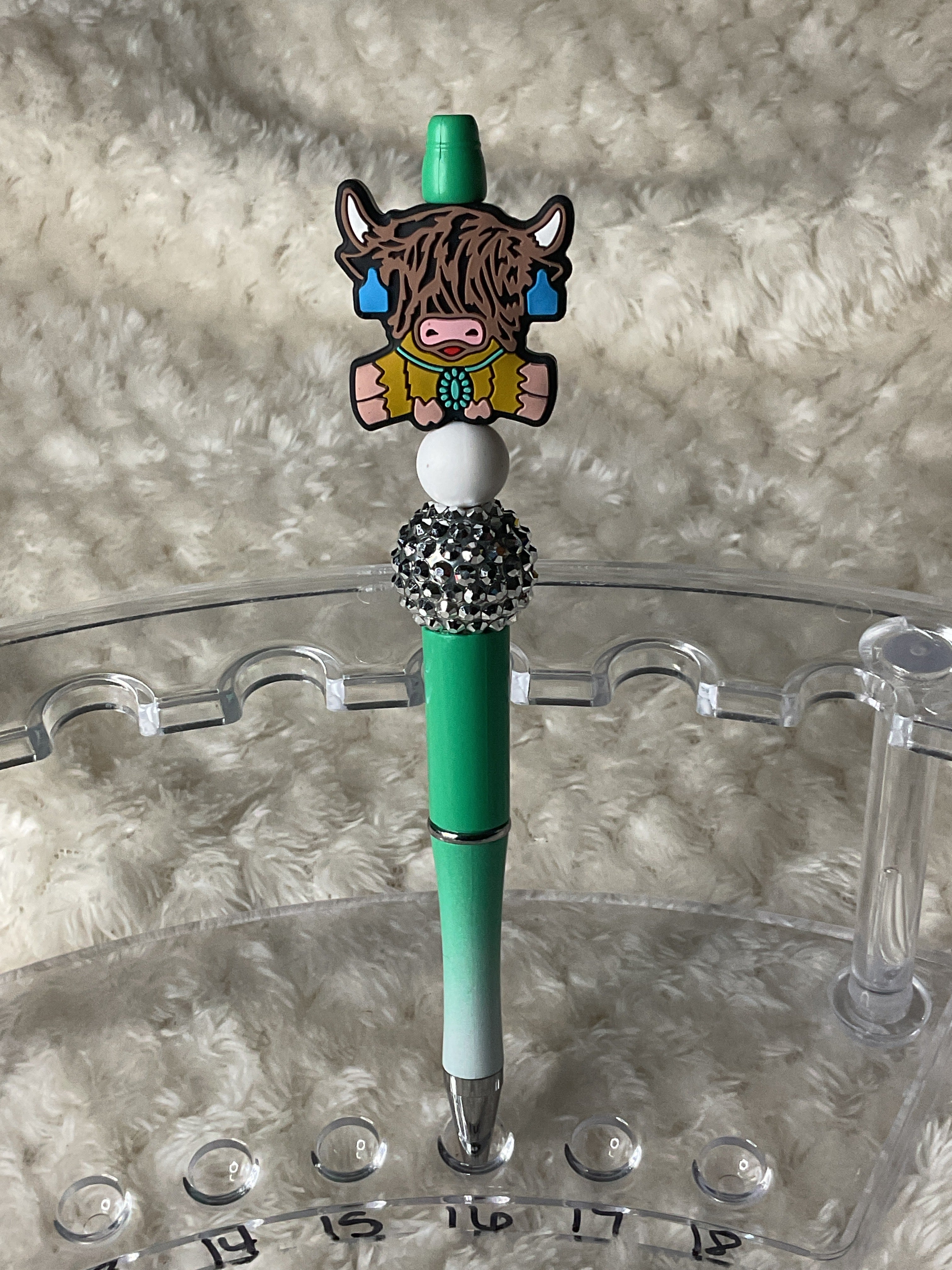 Highland cow wearing a turquoise necklace ￼￼