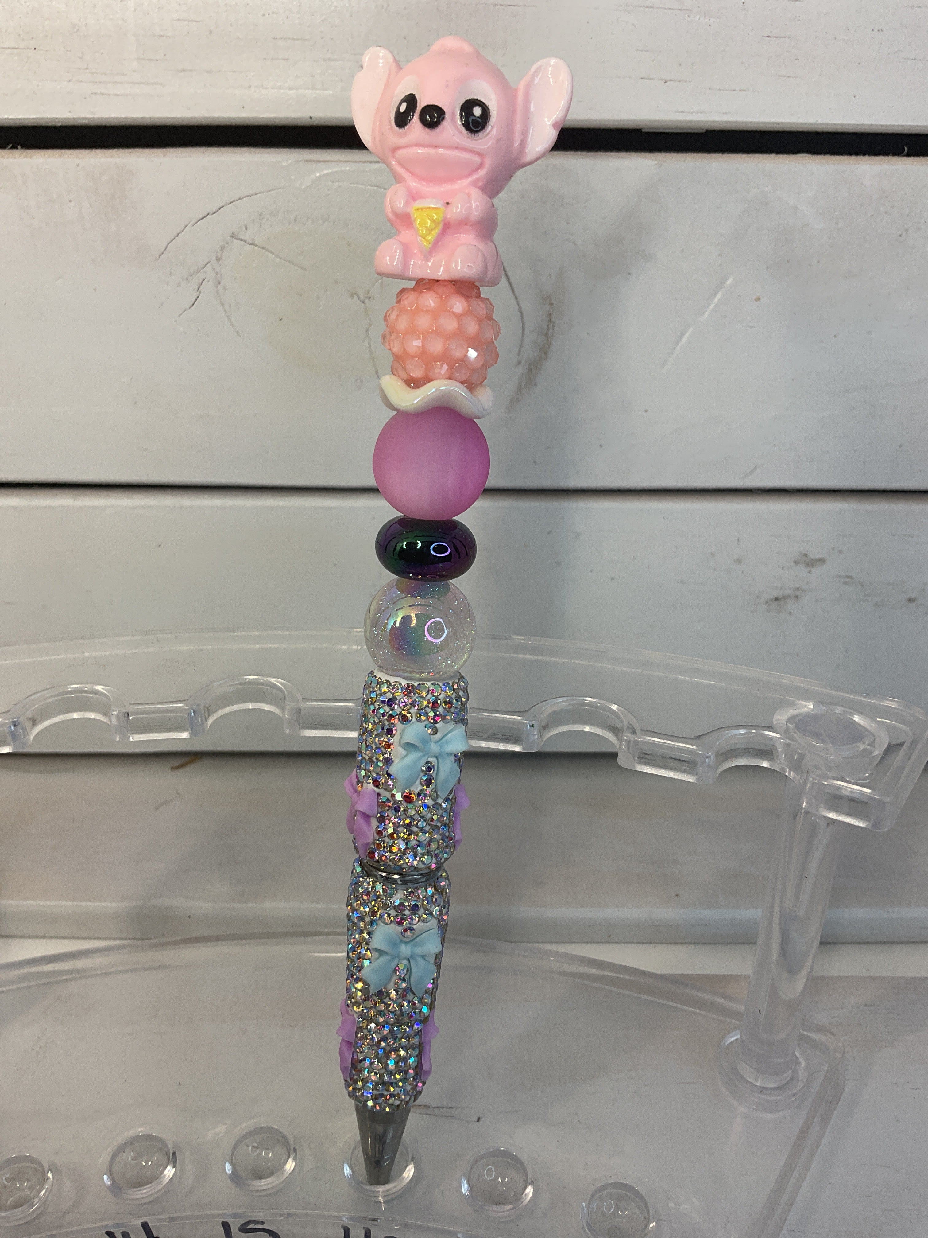 Angel on a silver rhinestone with pink and blue bows